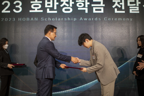 김상열 호반장학재단 이사장(왼쪽)이 9일 서울 서초구 호반파크 2관에서 ‘2023 호반장학금 전달식’에서 장학증서를 수여하고 있다.